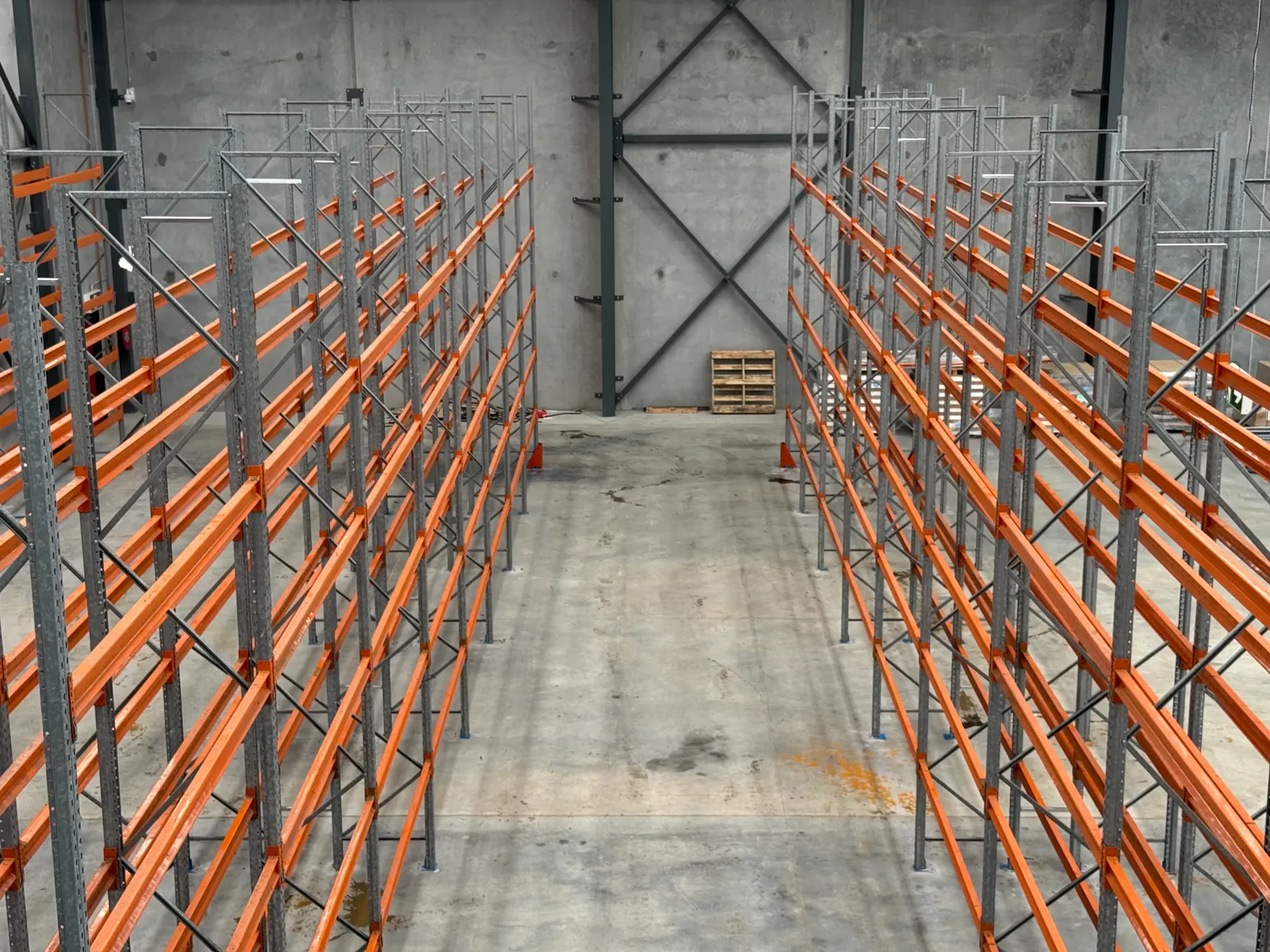 Rows of orange-beam used pallet racking ready for a warehouse fit-out